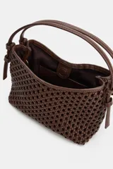 Mini bolso de mano de color marrón con diseño trenzado y doble asa de mano. Incluye función bandolera con correa extraíble, forro interior y cierre mediante botón imantado.