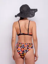 Conjunto de bikini con corpiño triangular con breteles finos y bombacha de tiro alto. Estampado multicolor con motivos florales y geométricos.