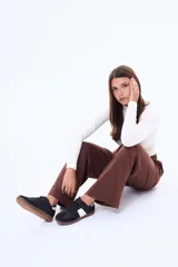 Champion de estilo urbano, color blanco con detalles en beige y suela de goma color caramelo. Presenta un diseño de líneas limpias con refuerzos en la puntera y laterales.