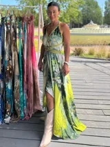 Vestido largo verde con diseño estampado tipo tie-dye y detalles dorados, de corte fluido, un solo hombro y diseño amplio.