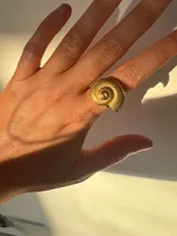 Anillo dorado de acero inoxidable con forma de caracola.