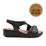 Sandalia de cuero color negro con plataforma baja y suela marrón.