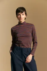 Polera de cuello alto y manga larga, confeccionada en tejido elástico con diseño de rayas horizontales en tonos azul marino y terracota.
