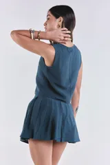 Chaleco azul petróleo con escote en V y lazo ajustable en el frente.