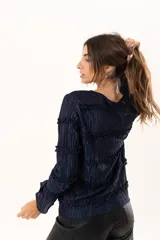 Blusa de manga larga en color azul marino, confeccionada en tejido plisado con detalles de volados horizontales a lo largo de toda la prenda.