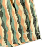 Short de baño con diseño de ondas verticales en tonos naranja, verde y beige. Cuenta con cintura elástica, dos bolsillos laterales y un bolsillo trasero con cierre.