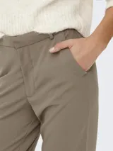 Pantalón de corte recto en color marrón claro, con bolsillos laterales y cierre de gancho. Confeccionado en mezcla de poliéster y elastano.