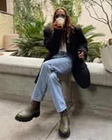 Bota tipo chelsea de cuero en color bordó, con paneles laterales elásticos, suela track negra de plataforma y tiradores en la parte superior.