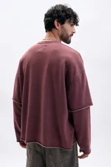 Sudadera color marrón con efecto desgastado, cuello redondo, manga larga con diseño de doble capa y bordes sin rematar. Estampa frontal con la palabra "TOKIO" en blanco.