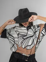 Sombrero de gamuza color tostado, estilo cowboy, con ala ancha y detalle de trenzado en la base de la copa.