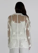 Camisa de crochet negra con botones dorados.