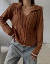Sweater de punto con diseño de trenzas, cuello en V con solapa tipo polo, manga larga y puños con detalle de franja negra en contraste.