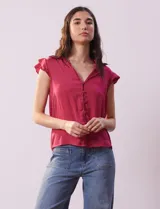 Camisa sin mangas color fucsia de satén, con cuello con solapa y escote en V. Tiene una apertura central con botones y volados en las sisas.