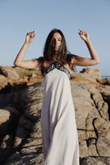 Vestido largo de lino en color beige, con escote halter y detalle de guarda pampa bordada en cuero en la parte superior.