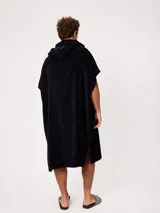Poncho de toalla negro con capucha y logo bordado en el pecho, diseño amplio y cómodo.