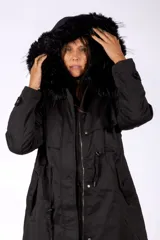 Campera parka color negro, con capucha forrada en piel sintética, cierre frontal con cremallera y botones a presión, y cordones ajustables en la cintura.