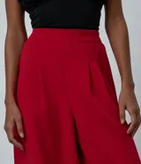 Pantalón de sastrería color rojo, modelo aladín con cintura alta, pinzas frontales y bajo ajustado. Confeccionado en tejido de viscosa con elastano.