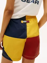 Shorts de nailon con diseño color block en rojo, amarillo y azul marino. Cuenta con dos bolsillos en la cintura y logo de Tommy Hilfiger en el bajo y la parte trasera.