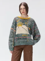 Sweater de tejido de punto con diseño gráfico de paisaje montañoso y elementos geométricos. Presenta cuello redondo, mangas largas holgadas y un ajuste suelto.