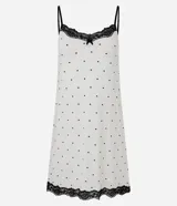 Camisón corto de viscolycra blanca con estampado de lunares negros. Presenta breteles finos ajustables y encaje negro aplicado en el escote y el bajo.