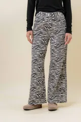 Jean de tiro medio a alto con estampa de cebra en blanco y negro, de corte wide leg. Posee bolsillos funcionales delanteros y traseros, y cierre frontal con botón.