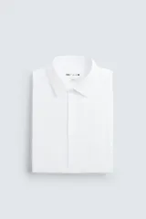 Camisa de corte slim fit con textura, cuello italiano y manga larga con puños abotonados. Presenta cierre frontal con botones.