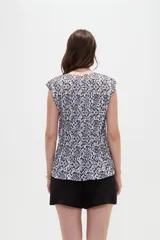 Blusa de poliéster sin mangas con cuello redondo y estampado geométrico en tonos marrones y blancos, de corte holgado y diseño fluido.