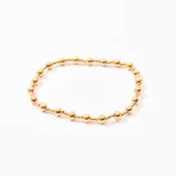 Pulsera dorada con cuentas esféricas de diferentes tamaños unidas por un hilo elástico.