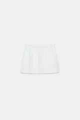 Falda corta blanca de tiro medio con cintura elástica y forro interior tipo shorts en el mismo tejido.