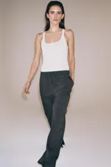 Pantalón de tiro medio con diseño de pierna ancha y estampado de rayas verticales. Cuenta con cintura elástica ajustable mediante cordones y bolsillos laterales ocultos en la costura, con aberturas en el bajo.