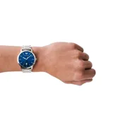 Reloj de pulsera Emporio Armani modelo Ruggero con caja de acero inoxidable plateado de 43 mm y esfera azul con acabado sunray. Presenta manecillas e índices plateados, ventana de fecha a las 6 y correa de acero inoxidable con cierre desplegable.
