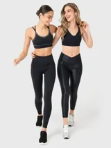 Calza deportiva de tiro alto con cintura cruzada en forma de V, confeccionada en tela brillante con acabado satinado y ajuste tipo segunda piel.