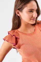 Top color salmón metalizado, de algodón peinado, con cuello redondo y mangas cortas con volados con borde fucsia.