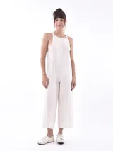 Monoprenda de lino color beige, con diseño de tirantes anchos, escote cuadrado y corte holgado con piernas anchas tipo culotte.