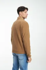Buzo de hombre con cierre frontal, confeccionado en tejido sherpa color camel, con paneles superiores en verde oliva acolchado y cuello alto en color beige.
