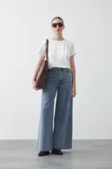 Remera básica de manga corta en color blanco, con cuello redondo y detalle de pliegues sutiles en los hombros.