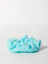 Gomita de pelo celeste con estampado de flores blancas.