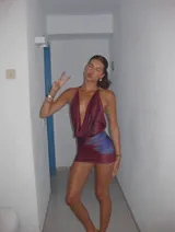 Vestido corto de satén con escote profundo tipo halter y espalda descubierta. Presenta un diseño estampado con degradado en tonos bordó y violeta.