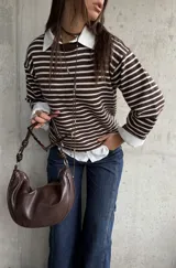 Sweater de punto a rayas horizontales en color chocolate y blanco, con cuello redondo y mangas largas con detalle de botones en los puños.