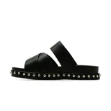 Sandalias planas Korium Kin color negro, con tiras cruzadas en el empeine y plataforma baja decorada con tachas metálicas doradas alrededor de la suela.