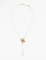 Collar dorado con dije irregular y cordones finos colgantes.