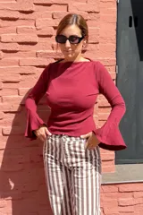 Remera de algodón color bordó, con mangas largas estilo oxford que presentan un diseño acampanado en los puños y escote bote.