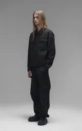 Chaqueta de corte regular crop confeccionada en microfibra pesada levemente elastizada. Presenta un diseño inspirado en la campera de jean clásica, con cuello volcado, cierre frontal mediante broches snap a tono y dos bolsillos delanteros con solapa.