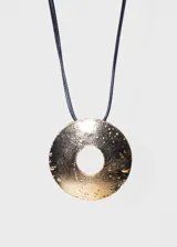 Collar con doble tira de cuerina negra y dije circular dorado con textura irregular.