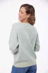 Sweater verde con estampado animal print celeste, de corte holgado y mangas largas.
