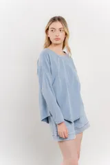 Remera manga larga color rosa con bolsillo en el pecho y corte irregular en el ruedo.