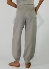 Pantalón de lino color rojo, de corte holgado con botamangas elastizadas y diseño cruzado en la cintura con lazo ajustable.