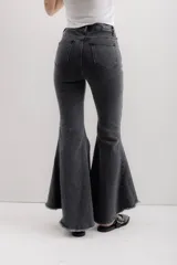 Jean elastizado azul oscuro con diseño de volados en la parte baja de la pierna, ruedo descosido con juego de largos (más largo atrás que adelante).