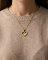 Dije de acero con baño de oro en forma de corazón calado con un pequeño corazón sólido en su interior.