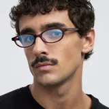 Lentes blueblocker con marco de forma geométrica y diseño ovalado en color bordó traslúcido. Cuentan con protección contra luz azul y rayos UV400.